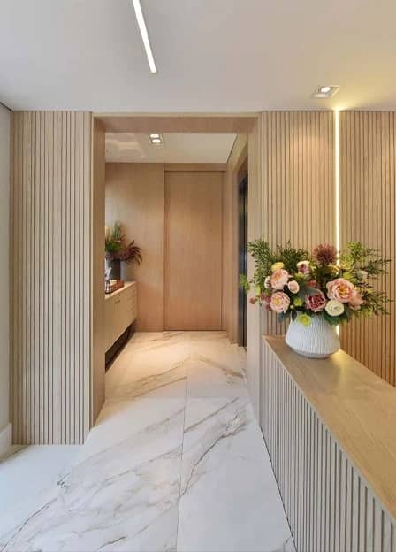 Corredor da Q!Clinic com painel ripado e arranjo de flores